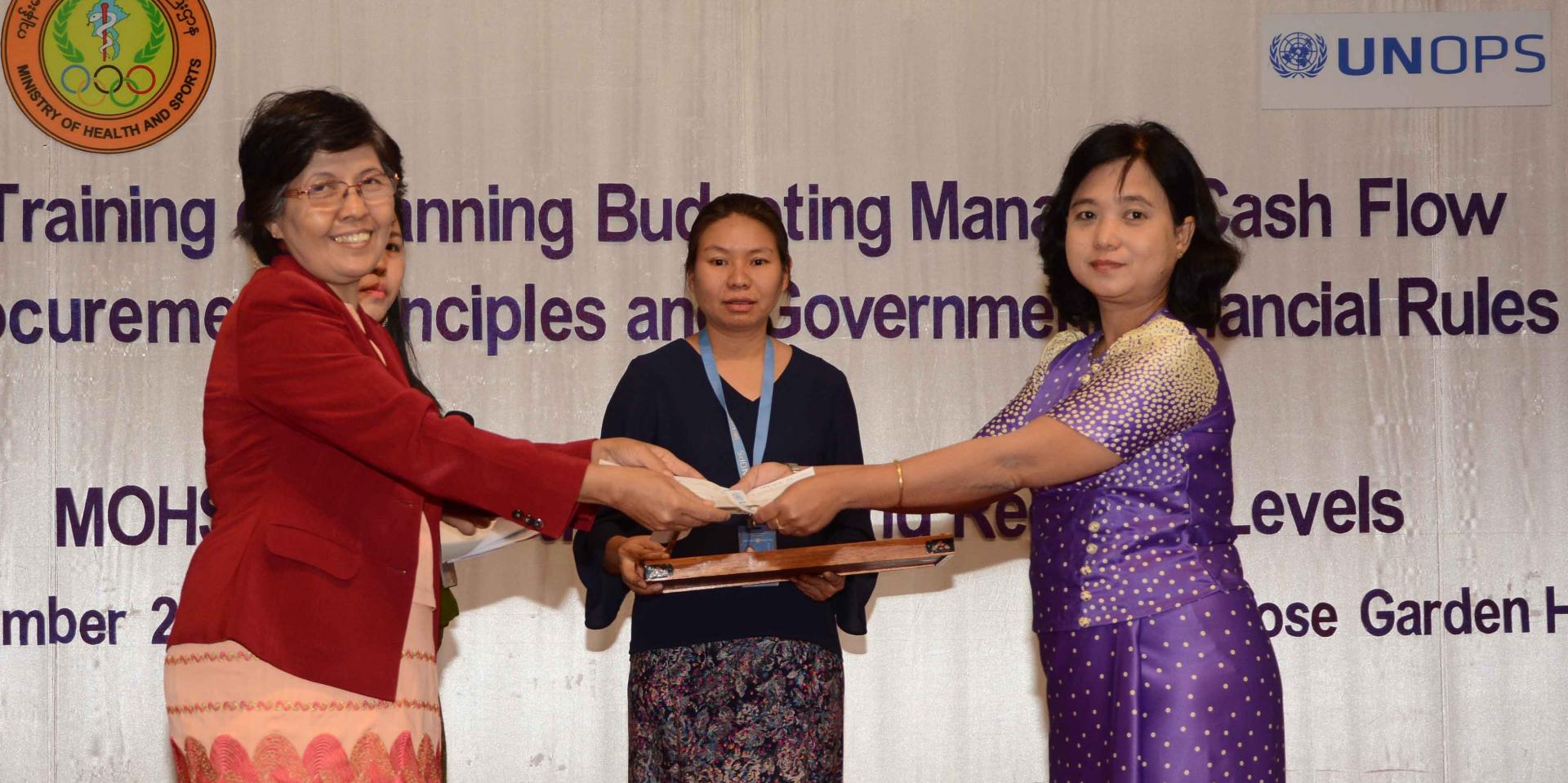 MOHS Yangon Region Deputy Director (Disease Control) Dr Khin Nan Lon presents prizes to participants who scored high marks in the practical workplanning exercises. Photo: UNOPS MOHS Yangon Region Deputy Director (Disease Control) Dr Khin Nan Lon presents prizes to participants who scored high marks in the practical workplanning exercises. Photo: UNOPS