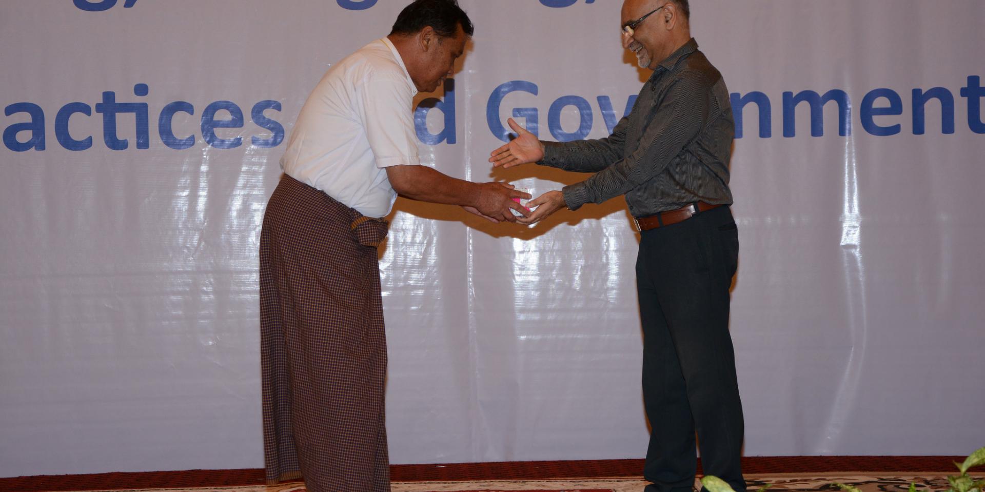 Dr Faisal Mansoor, Head of Programme Unit, PR-UNOPS, awards prizes for group-work exercises.
