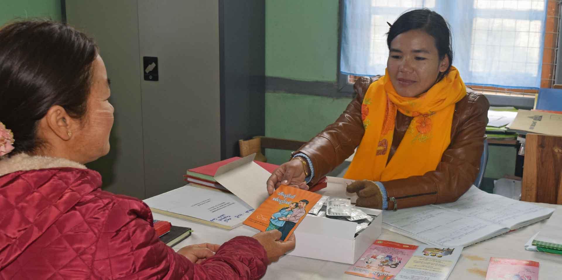 May Zin Htun hands out HIV education pamphlets on prevention of mother-to-child transmission of HIV during a counselling session at Hakha National AIDS Programme office.  Photo: UNOPS