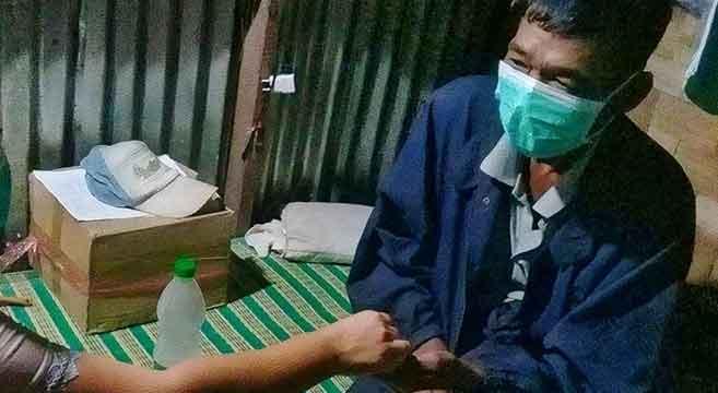 U Nyi Nyi Aung takes a dose of anti-TB medicines, administered as a directly observed treatment by a Pyi Gyi Khin community TB volunteer