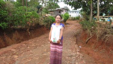 A caregiver from Pyi Gyi Khin’s HIV/AIDS project is on her way to a beneficiary’s home as part of the Community Home Based Care and Support activity with support from the Global Fund.