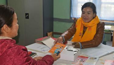 May Zin Htun hands out HIV education pamphlets on prevention of mother-to-child transmission of HIV during a counselling session at Hakha National AIDS Programme office.  Photo: UNOPS