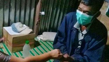 U Nyi Nyi Aung takes a dose of anti-TB medicines, administered as a directly observed treatment by a Pyi Gyi Khin community TB volunteer