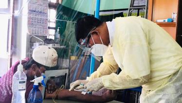 Peer educator Min Min Naing performing blood testing with protective measures at Pyigyitagon KSC. Photo: MANA