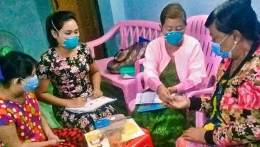 Daw Inn Inn Hlaing takes a dose of anti-TB medicine, administered as directly observed treatment by a community TB volunteer during a home visit